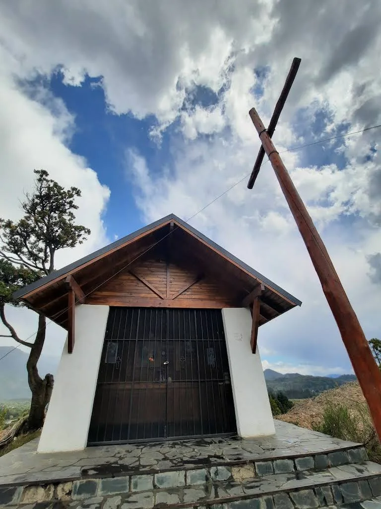 La ermita de Nahuel Malal, de madera y paredes blancas, con la cruz al lado